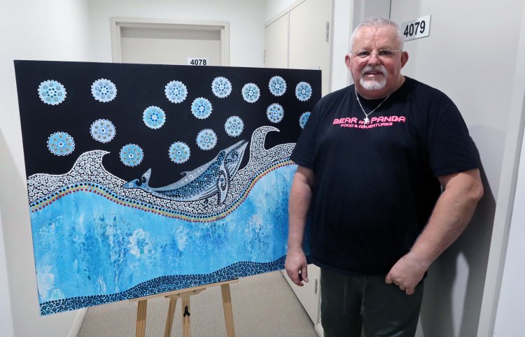 Robb Wang standing beside a blue whale painting
