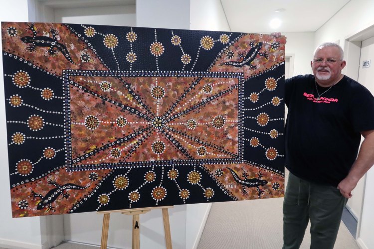 Robb Wang with a large earth-toned geometric painting